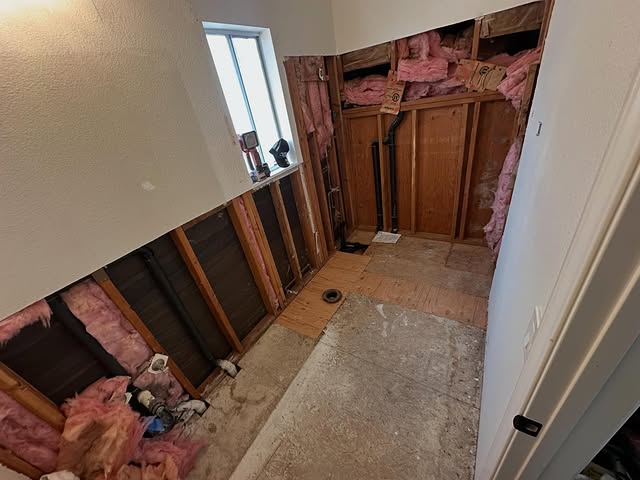 Bathroom demolition exposing old drain lines during a remodel