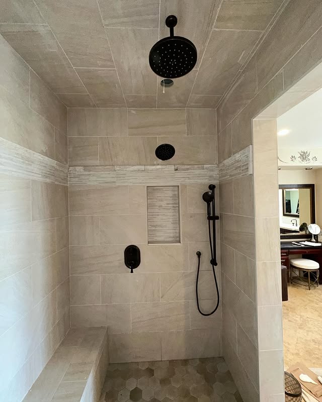 Finished custom tile shower with black fixtures installed by Next Level Plumbing